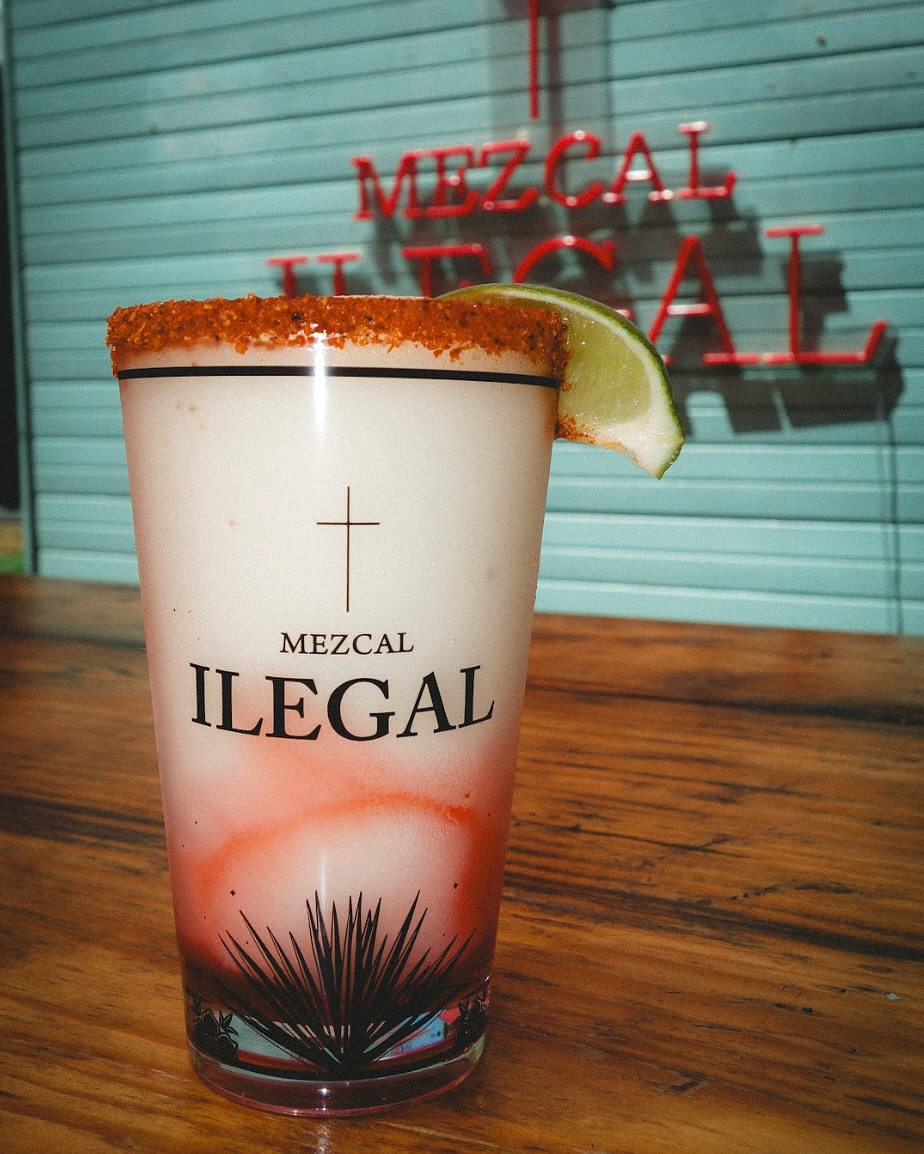 Blended Mezcal Ilegal drink with spiced rim, lime, and red swirl.