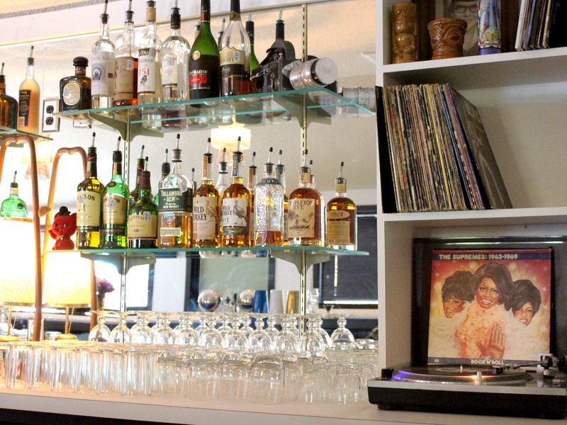Bar with liquor bottles, drinking glasses, and a record player.
