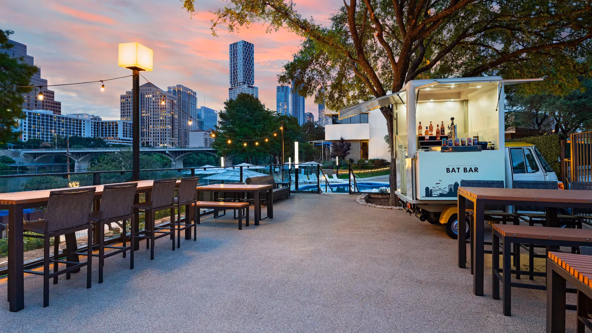 Bat Bar food truck on patio overlooking city skyline and river.