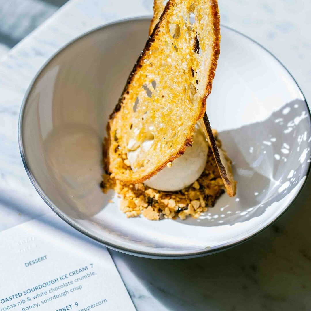 Toasted sourdough ice cream with crumble and sourdough crisps in a bowl.