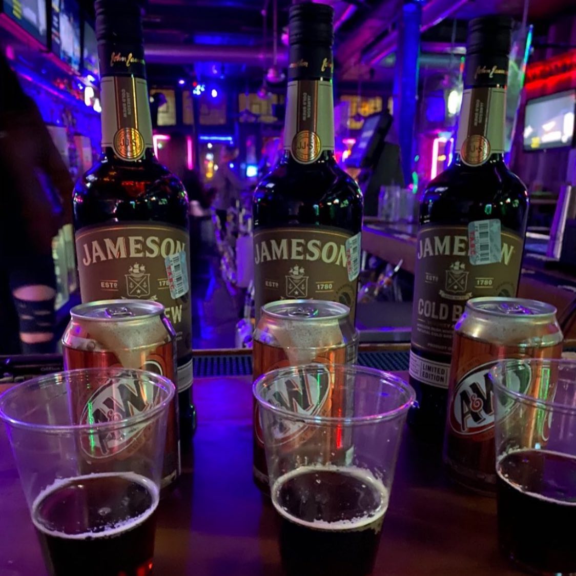 Jameson Cold Brew bottles, A&W root beer, and drinks on a bar.