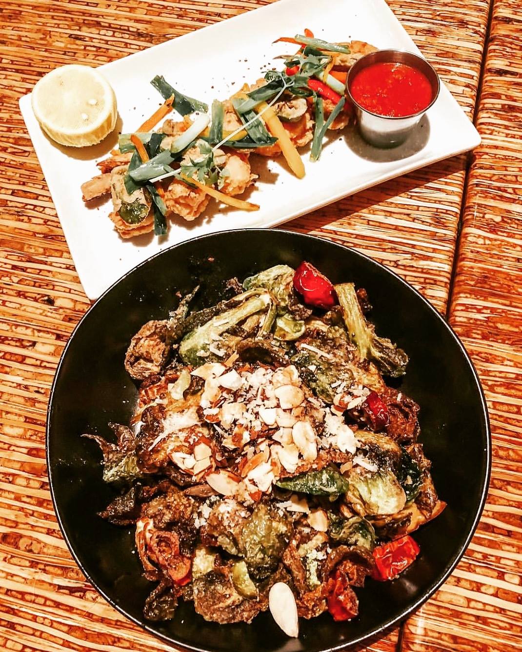 Fried food with vegetables, and roasted vegetables topped with almonds.