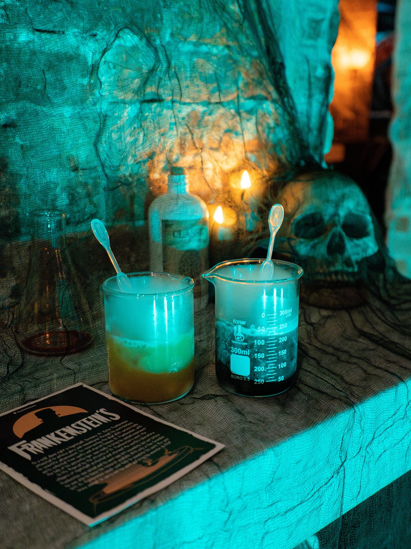 Halloween lab scene with bubbling drinks, skull, and Frankenstein decoration.