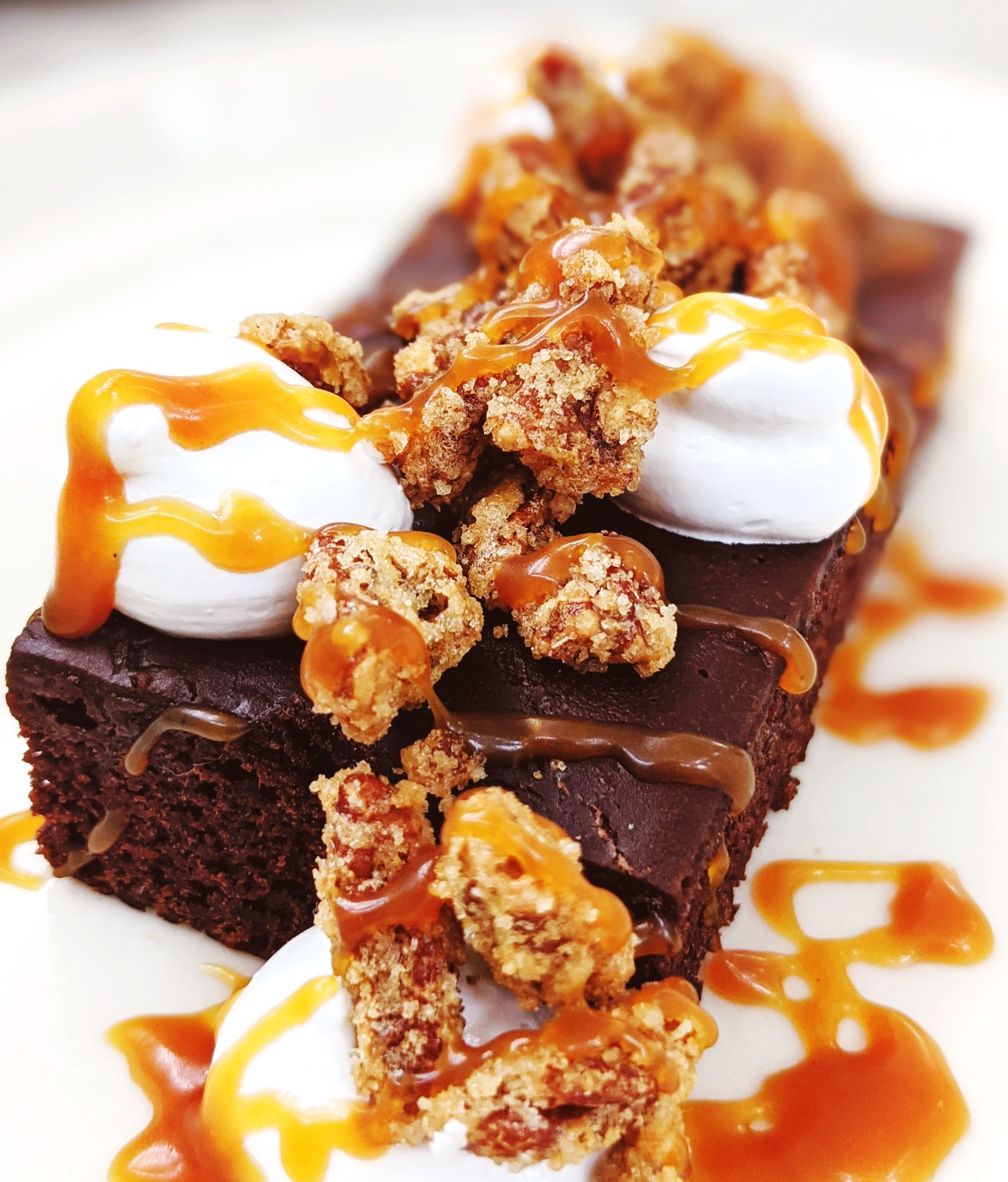 Chocolate brownie with whipped cream, caramel sauce, and crunchy topping.