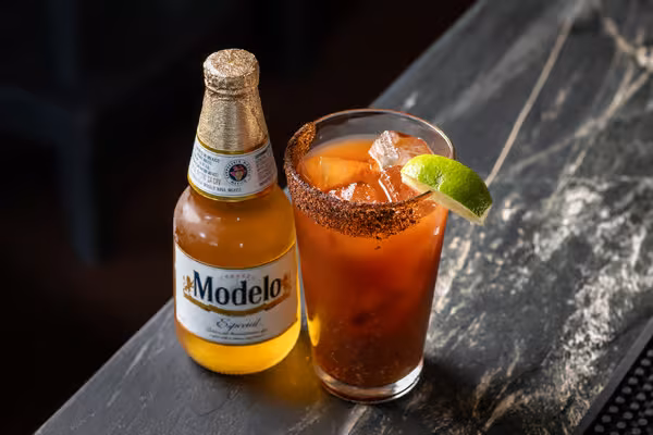 Modelo Especial beer bottle and a spiced beer cocktail with lime.