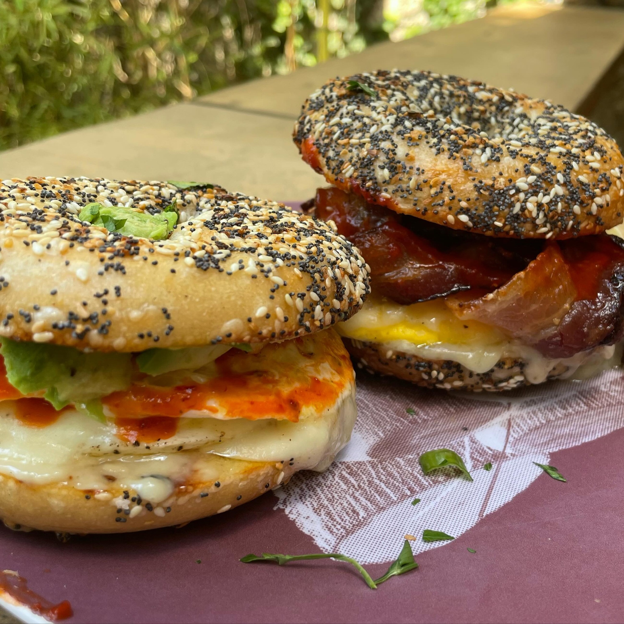 Two everything bagels with bacon, egg, avocado, and cheese.