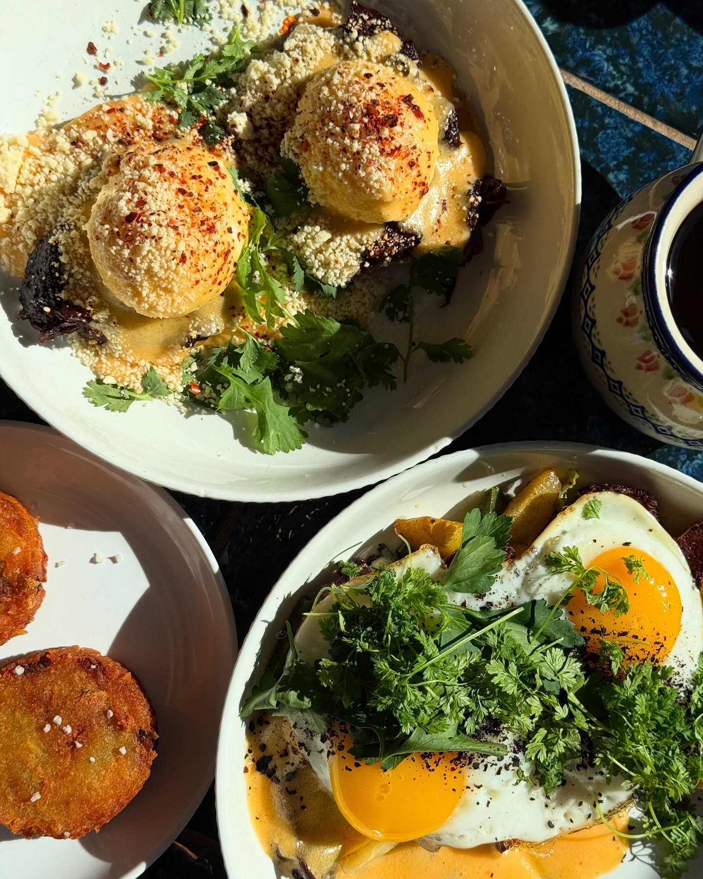 Two distinct egg dishes, fried patties, and a patterned ceramic pitcher.
