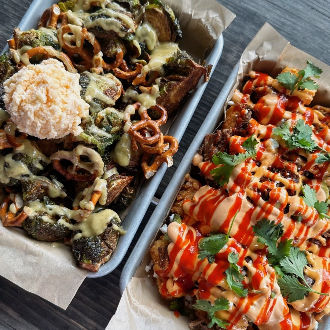 Two trays showing loaded Brussels sprouts and loaded fries.