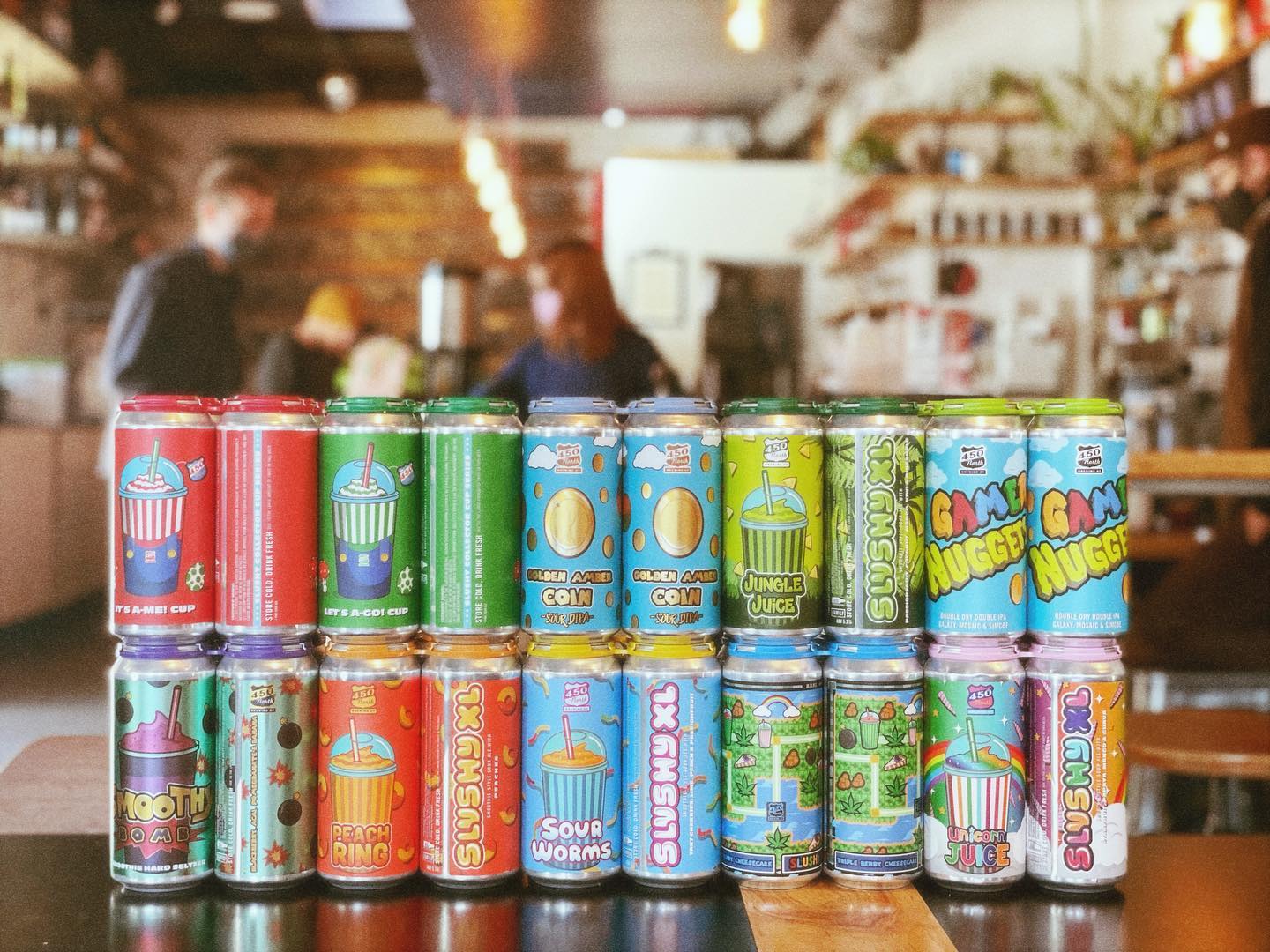 Two rows of vibrantly colored craft beer cans on display.
