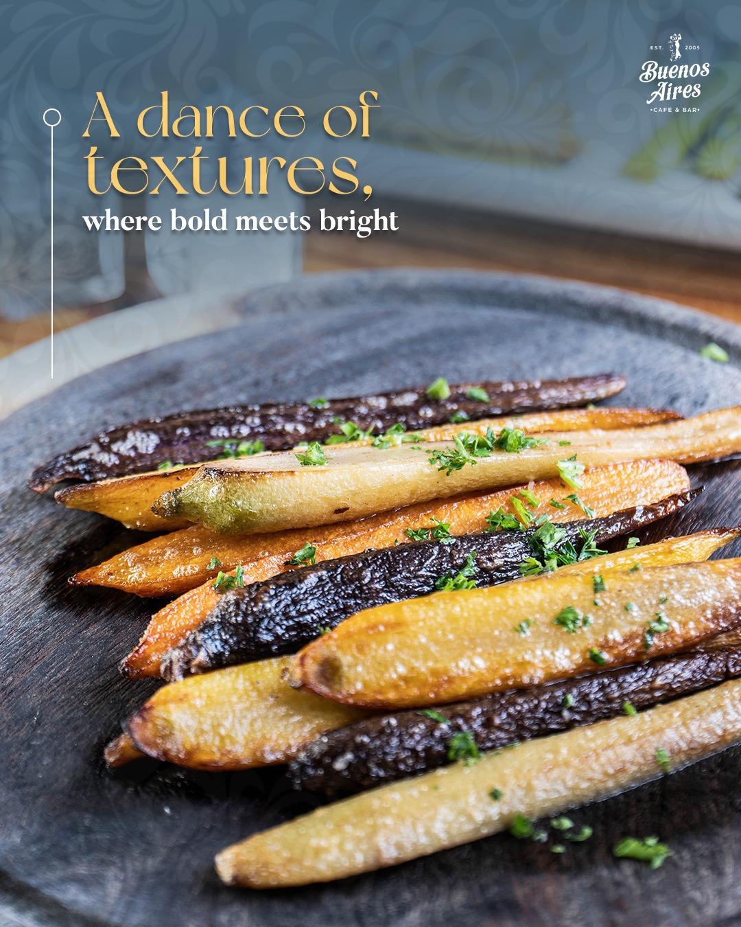 Colorful roasted carrots, garnished with herbs, on a dark board.