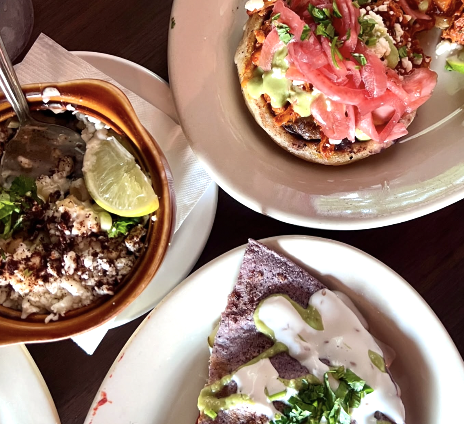 Three plates of Mexican food: a sope, blue corn tortilla, and rice.