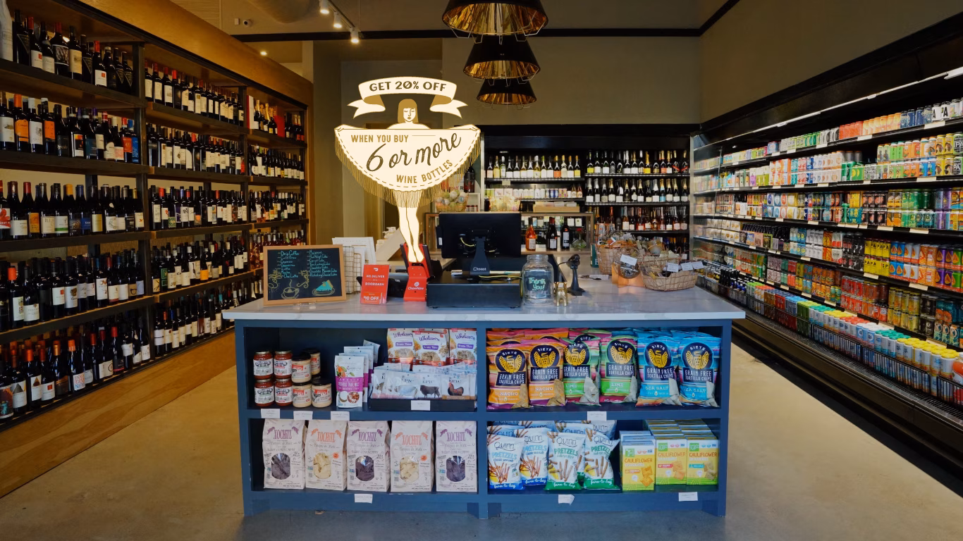 Market interior with wine, refrigerated beverages, snacks, and checkout.