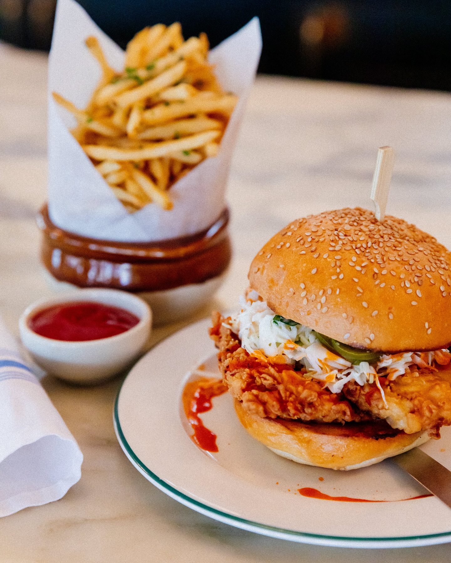 Crispy fried chicken sandwich with coleslaw, fries, and ketchup.