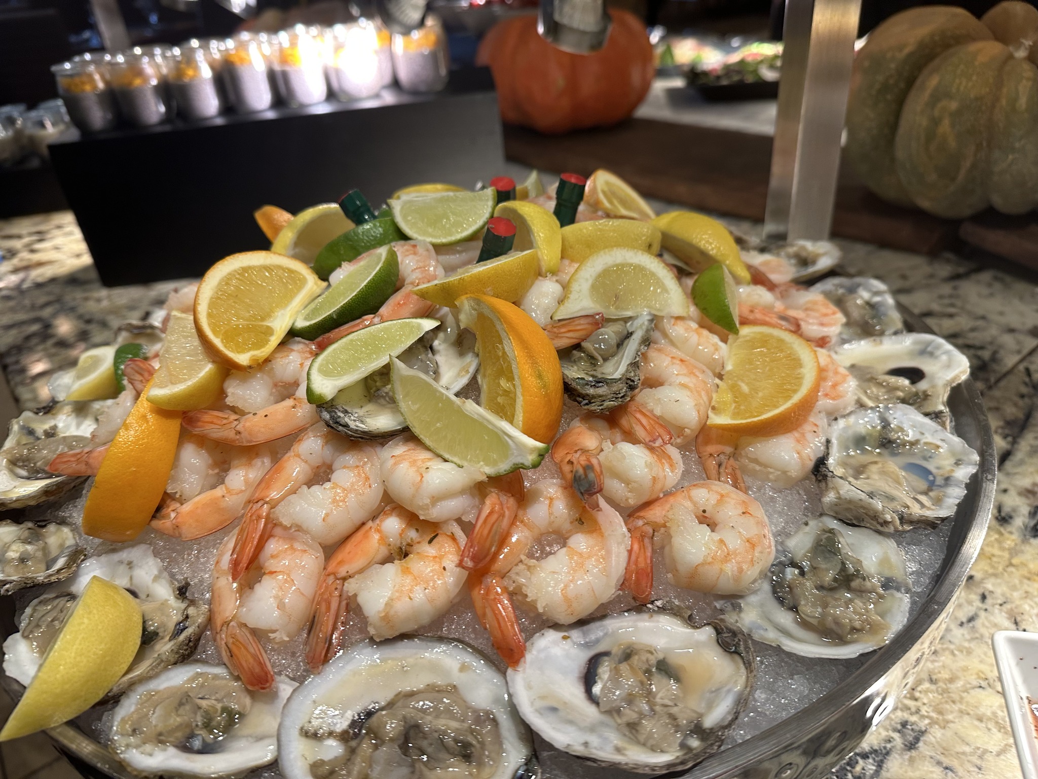 Shrimp and oysters on ice with lemon, lime, and orange slices.