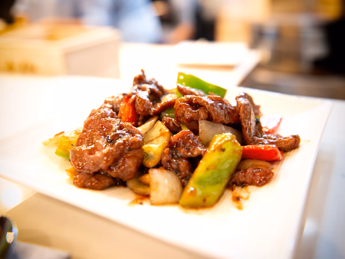 Plate of stir-fried beef with bell peppers and onions.