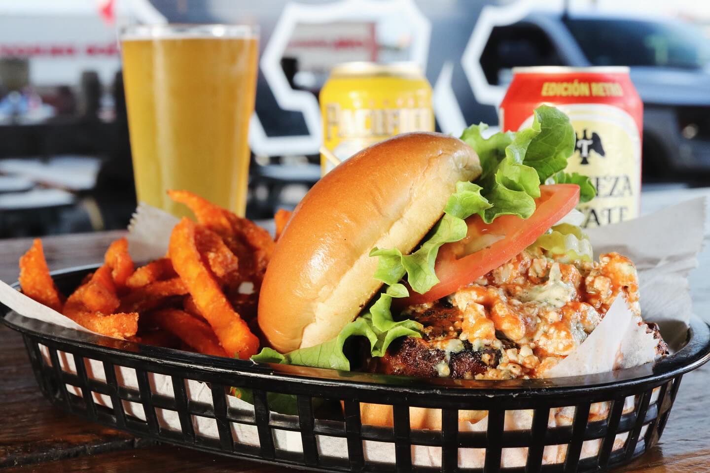 Burger, fries, and beer in a black basket.