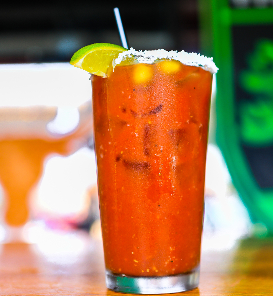 Iced red drink with a salt rim, lime, and straw.