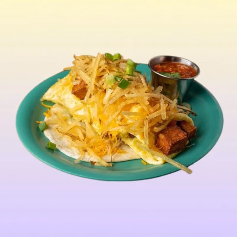 Breakfast plate with egg, fried potatoes, cubed meat, cheese, and salsa.