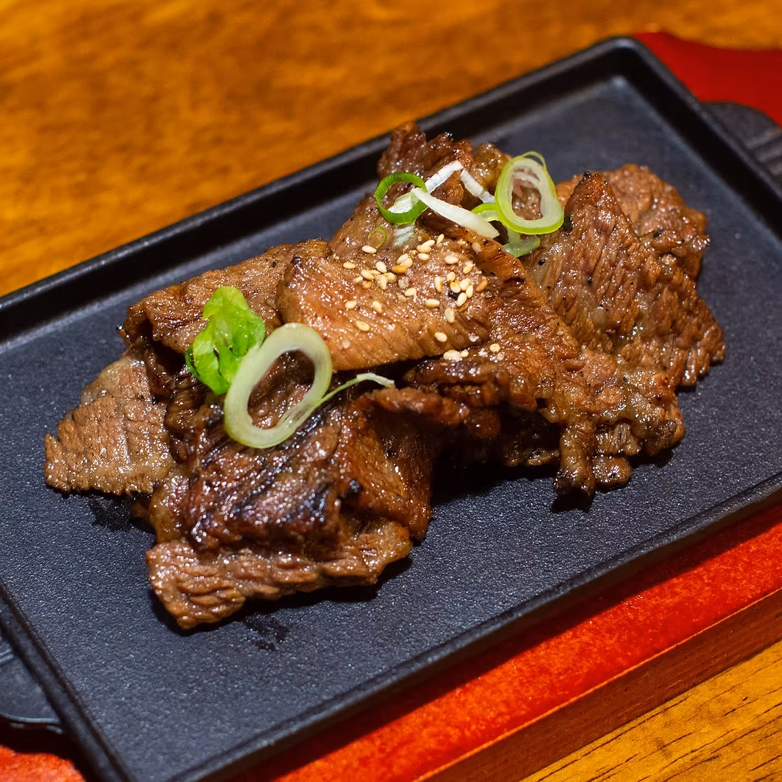 Grilled beef with sesame seeds and sliced green onions.