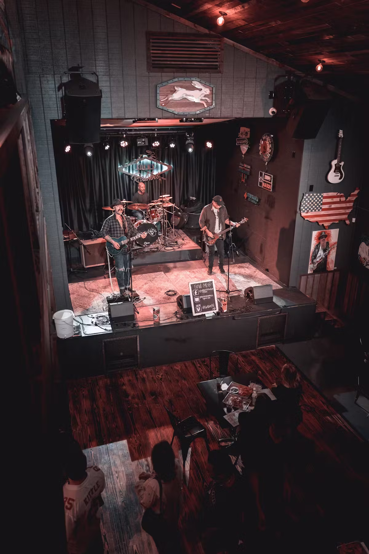 Overhead view of a band performing on stage in a rustic bar.