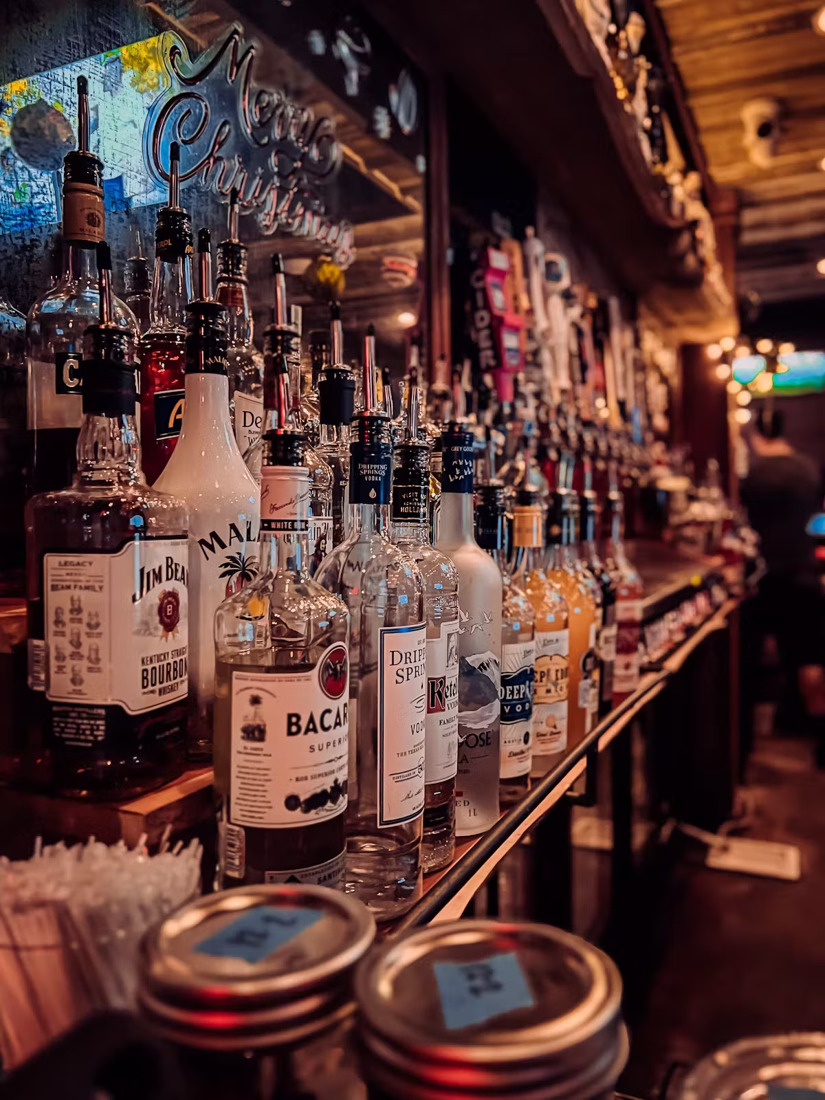 Bottles of spirits and beer taps displayed on a bar shelf.