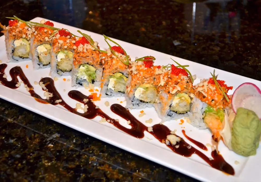 Sushi rolls with tempura shrimp, crispy topping, roe, and sauce.