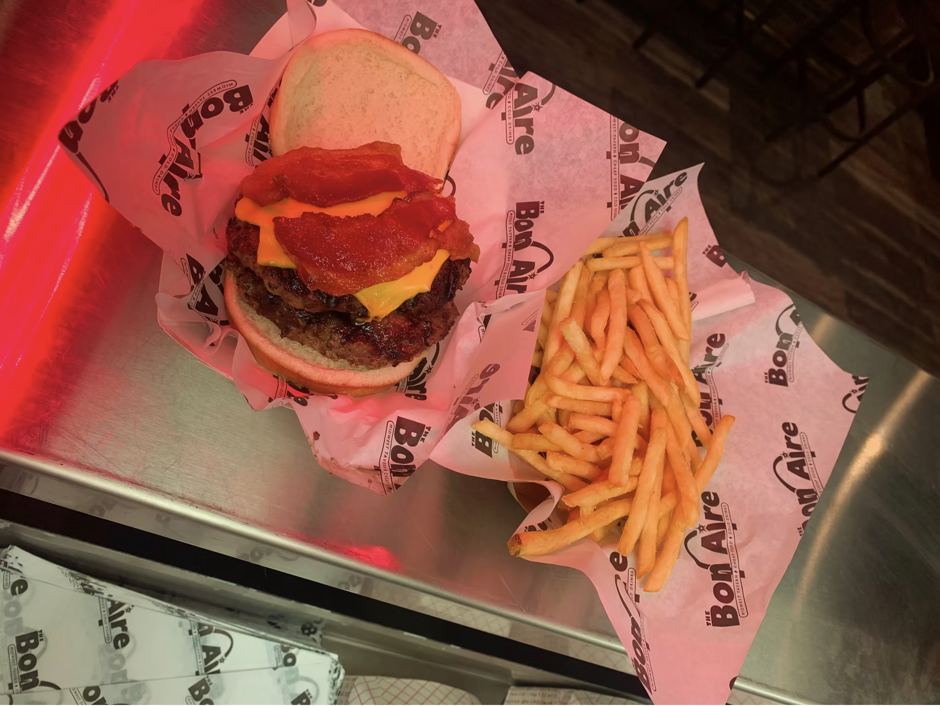A double bacon cheeseburger and fries on Bon Aire paper.
