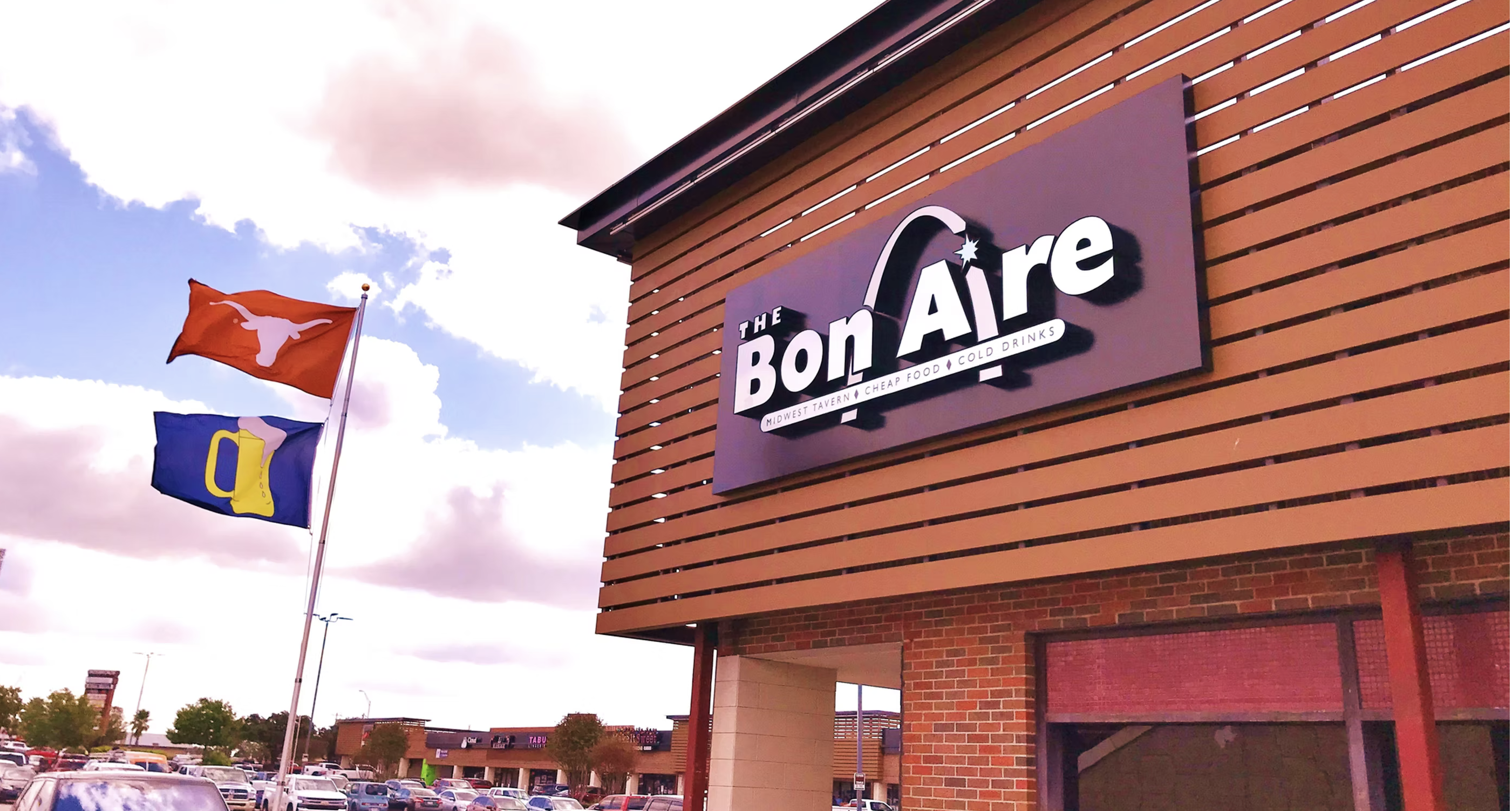 The Bon Aire building with Texas Longhorn and beer mug flags.