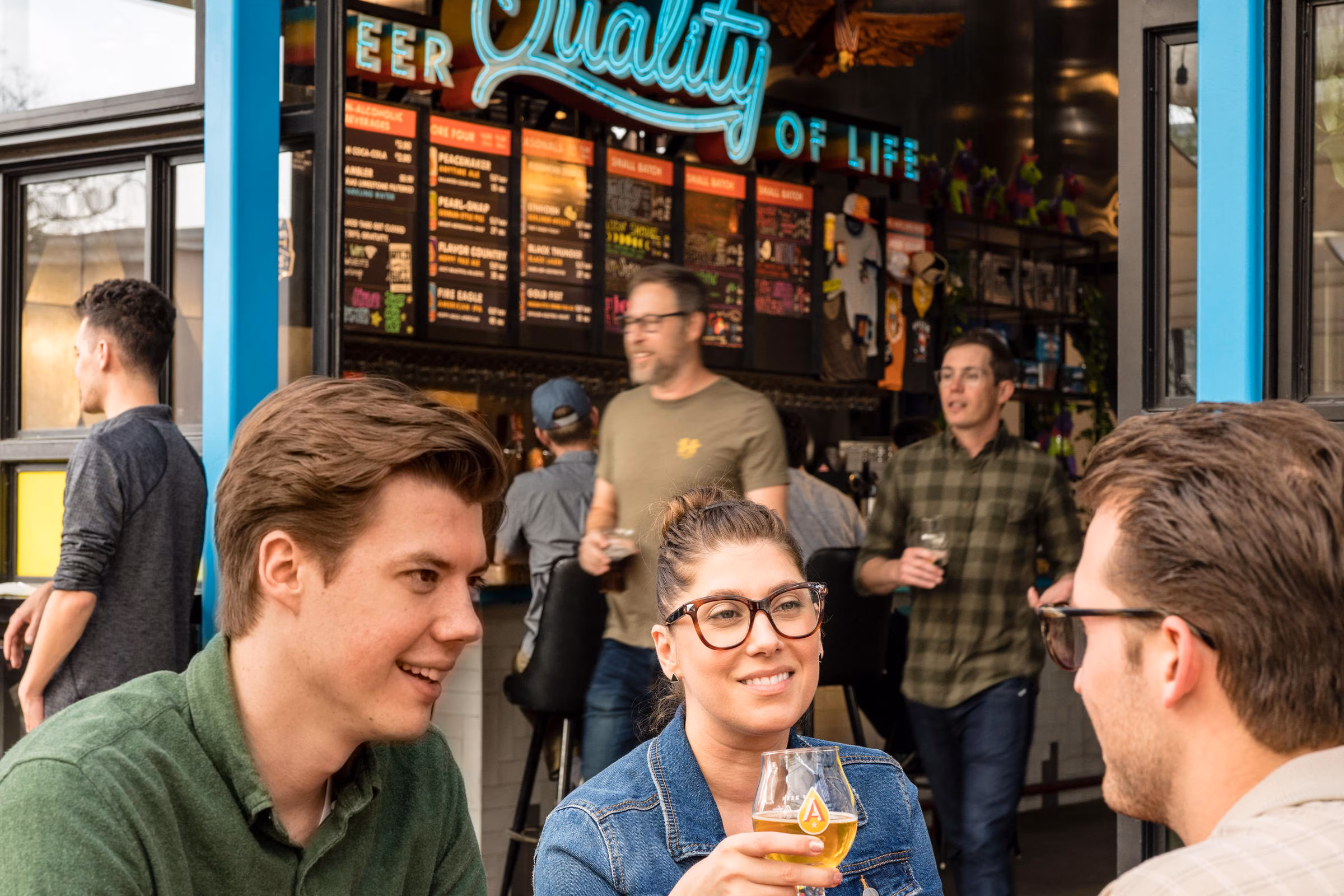 People enjoying beer and conversation inside a brewery.