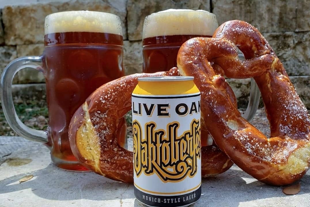 Two dark beers, two salted pretzels, and an Oktoberfest lager can.