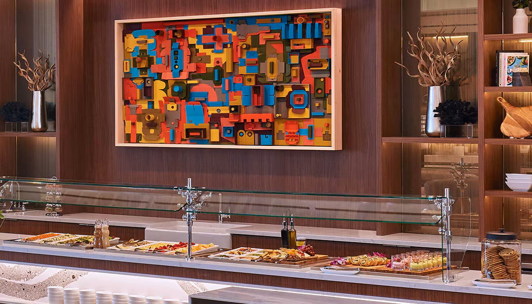 Colorful abstract art piece above a food buffet counter.