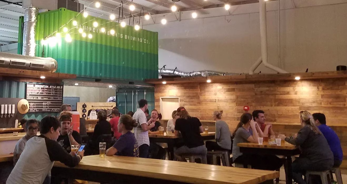 Southern Heights Brewing Co. interior with people and green container.