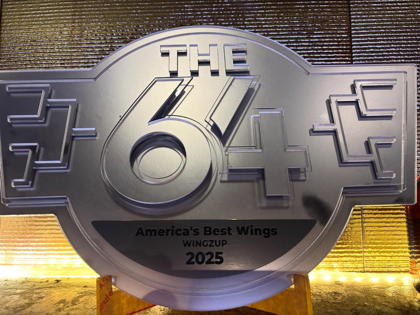 A silver plaque displaying "The 64" and "America's Best Wings 2025".