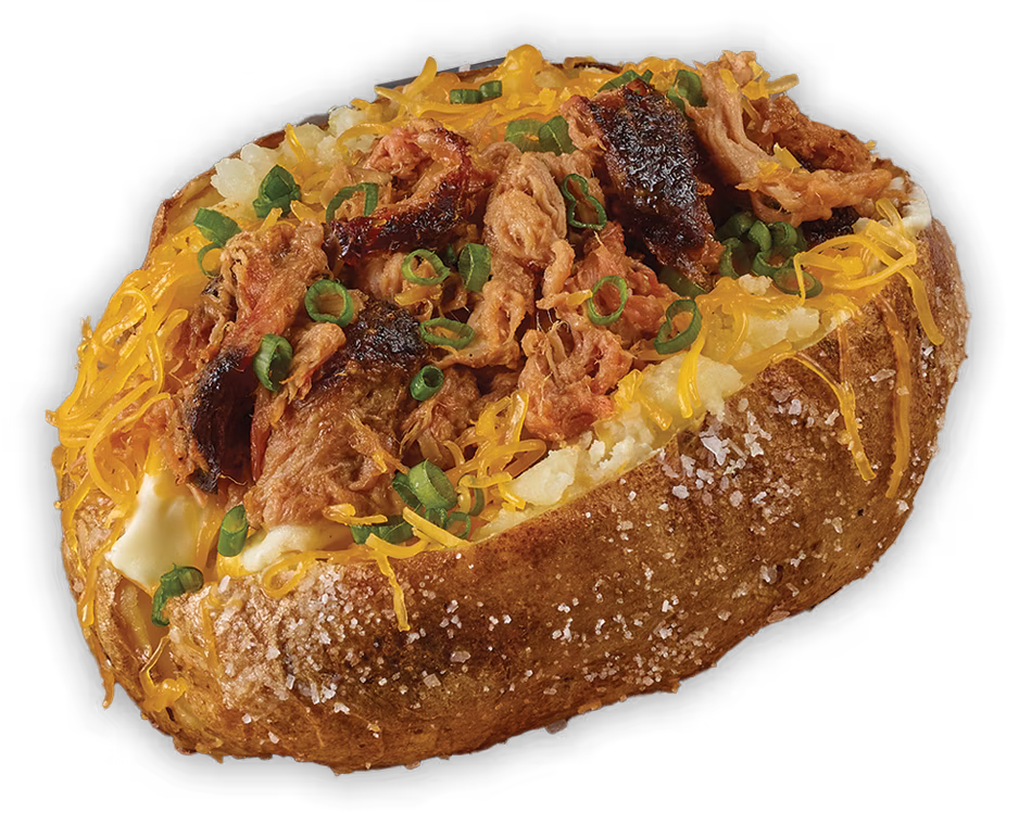 Baked potato with pulled meat, shredded cheese, and green onions.