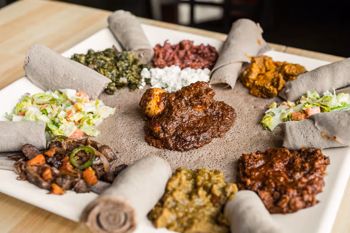 Ethiopian injera platter with various stews and rolled bread.