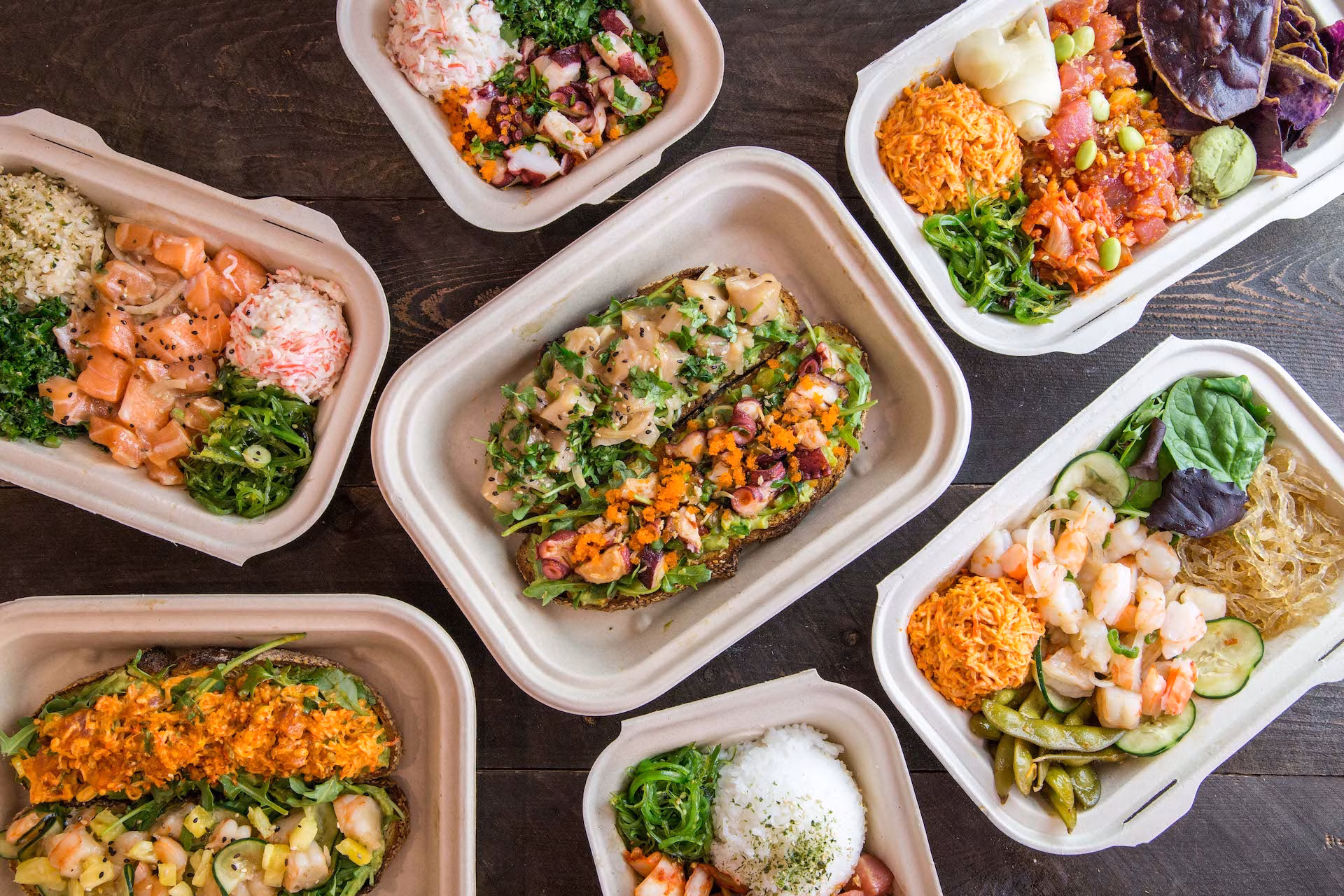Assorted poke bowls and toasts with various seafood and toppings.
