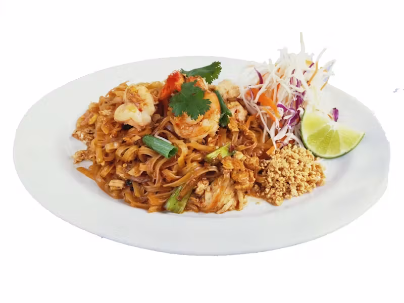 A plate of shrimp Pad Thai with lime, peanuts, and vegetables.