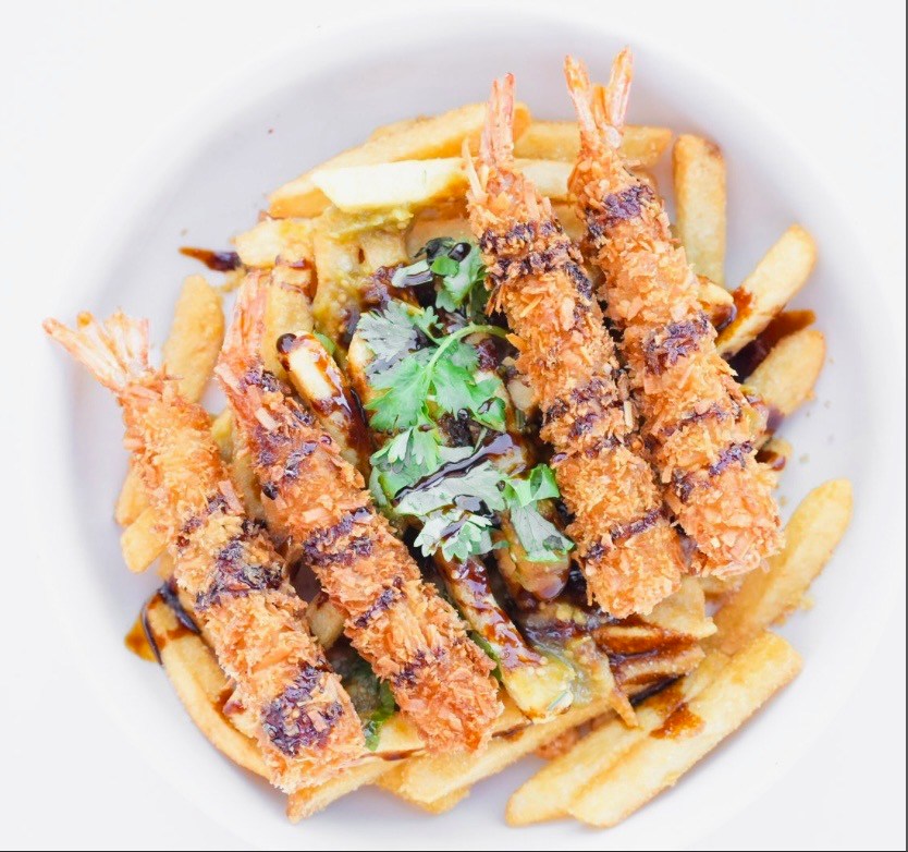 Five breaded shrimp and french fries with sauce and cilantro.