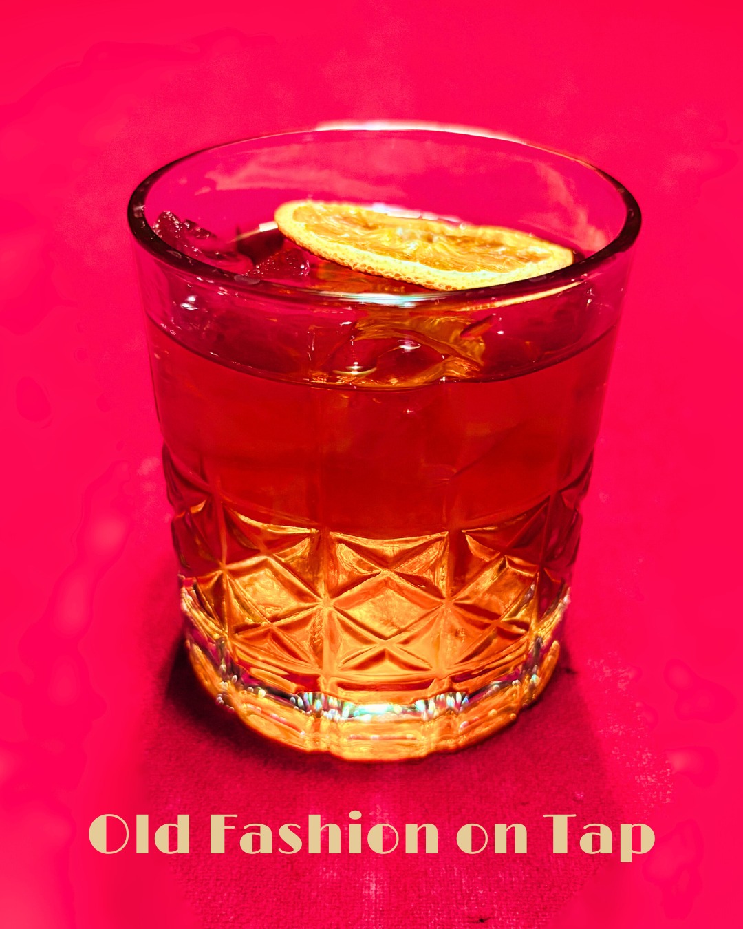 An old fashioned cocktail with an orange slice on a red background.