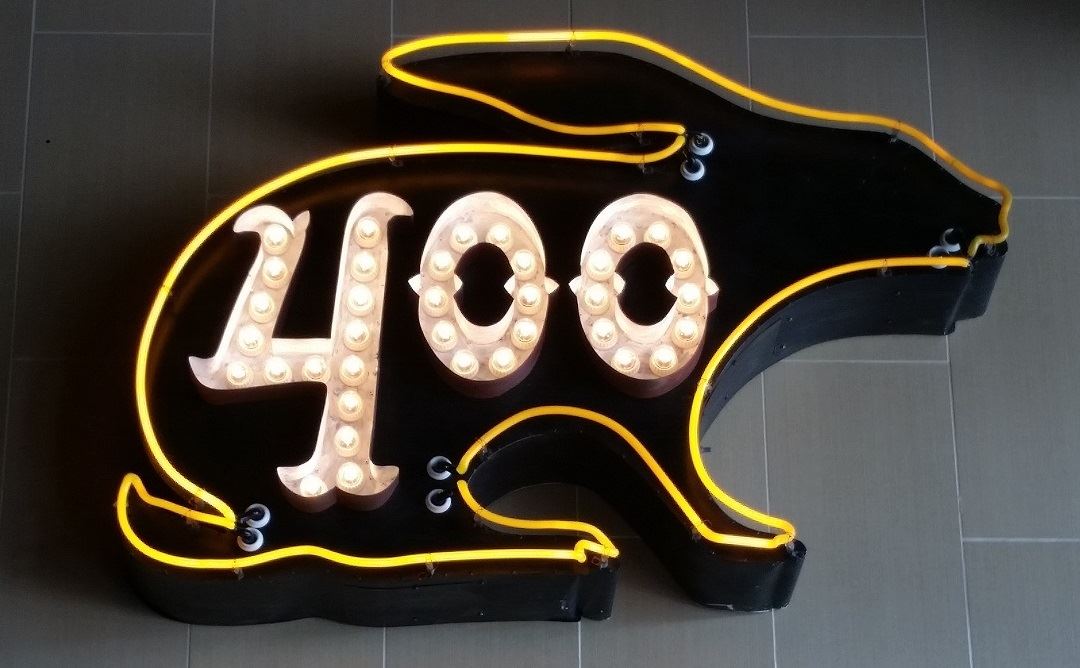 Black rabbit-shaped sign with yellow neon and lit numbers 400.