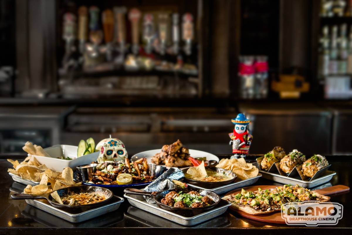 Multiple Mexican dishes and a sugar skull on a bar.
