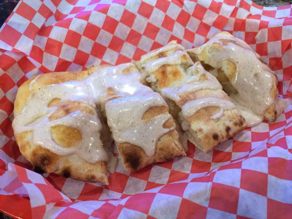 Flatbread pieces with creamy speckled sauce in a red checkered basket.