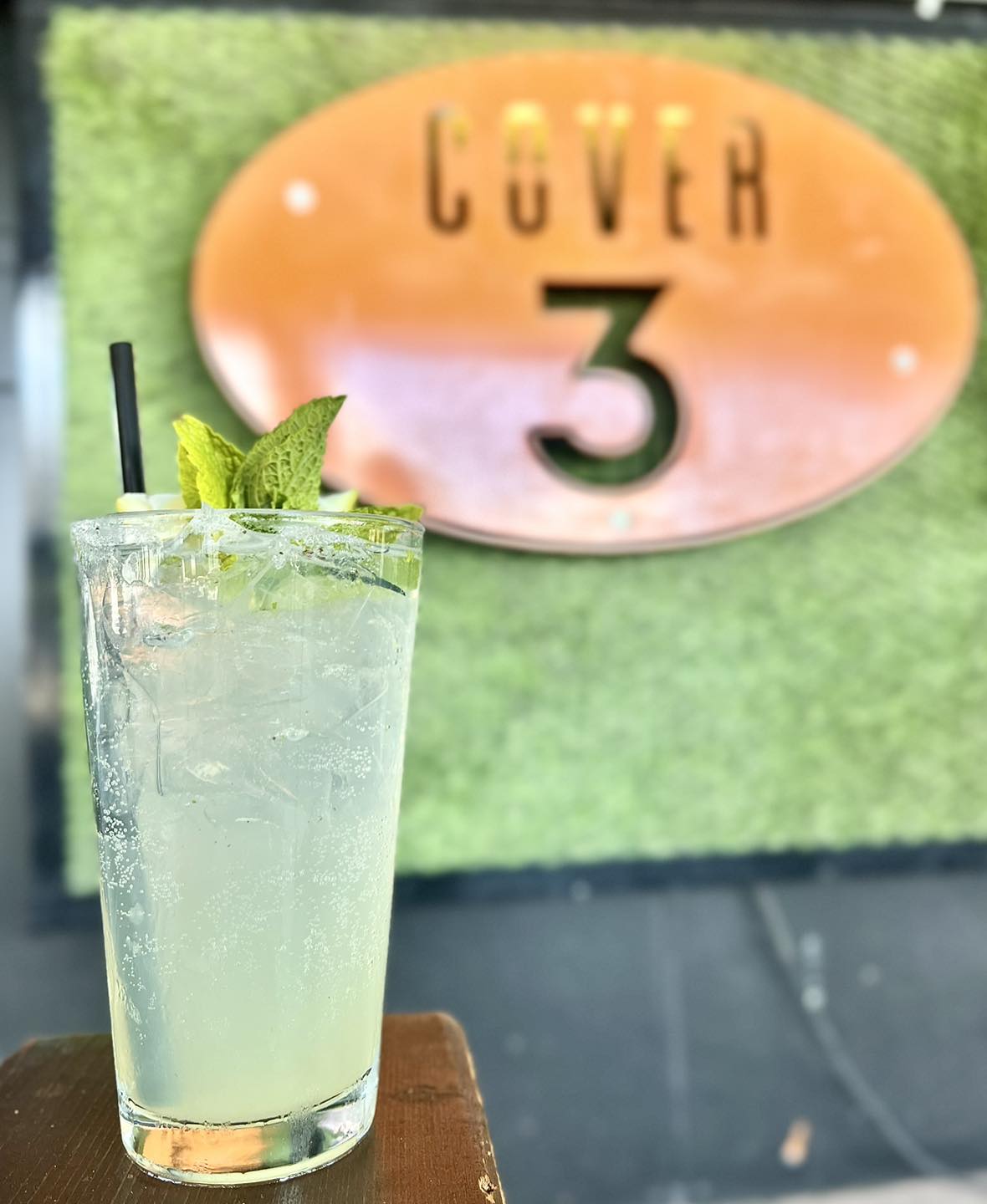 Sparkling drink with mint and straw in glass, with blurred Cover 3 sign.