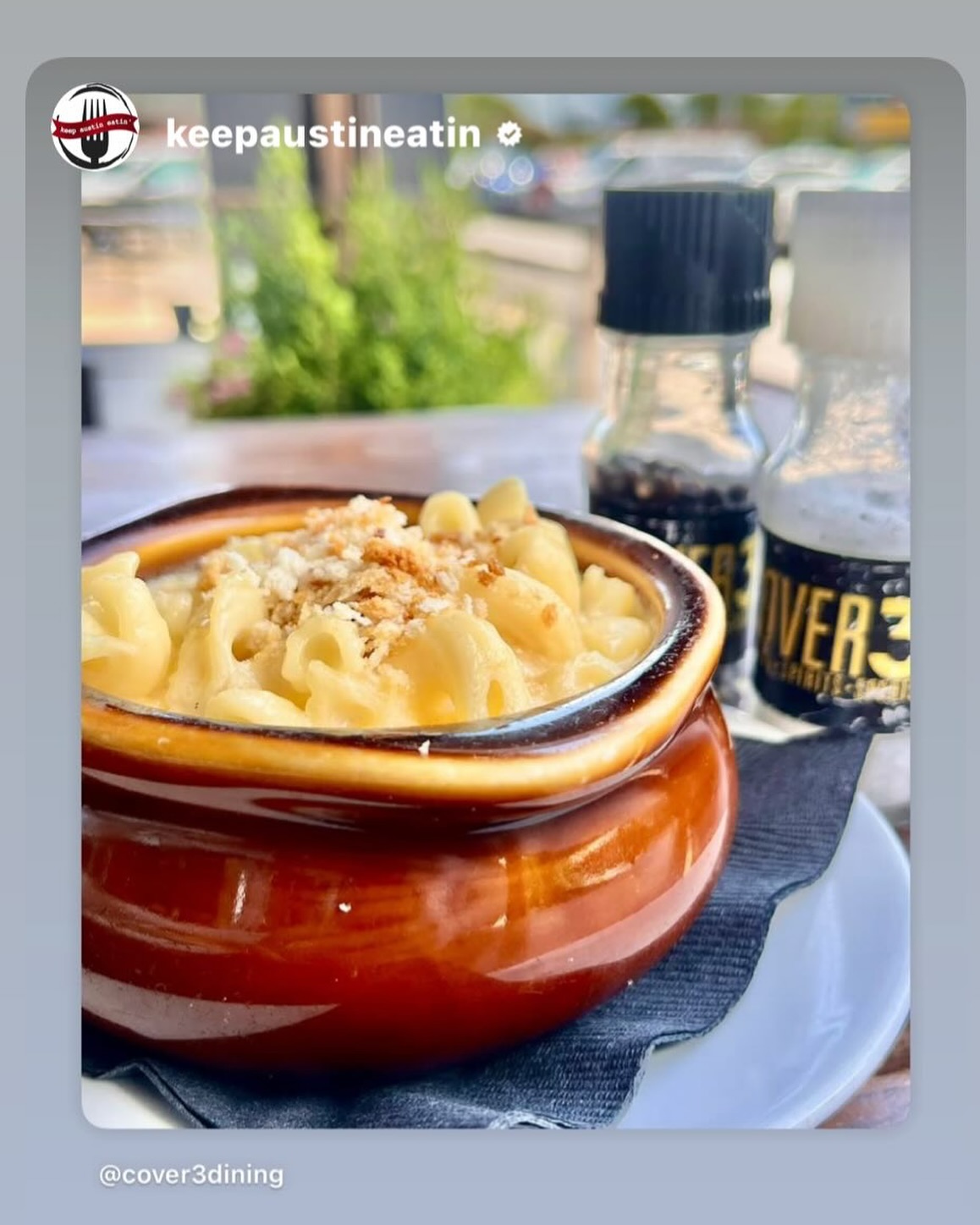 A brown crock of macaroni and cheese with breadcrumbs.