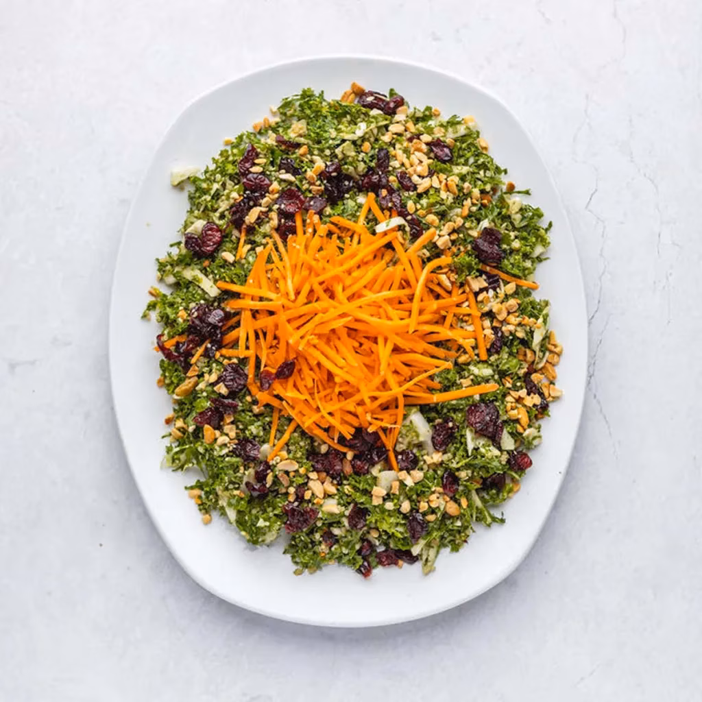 Green salad with shredded carrots, cranberries, and chopped nuts.
