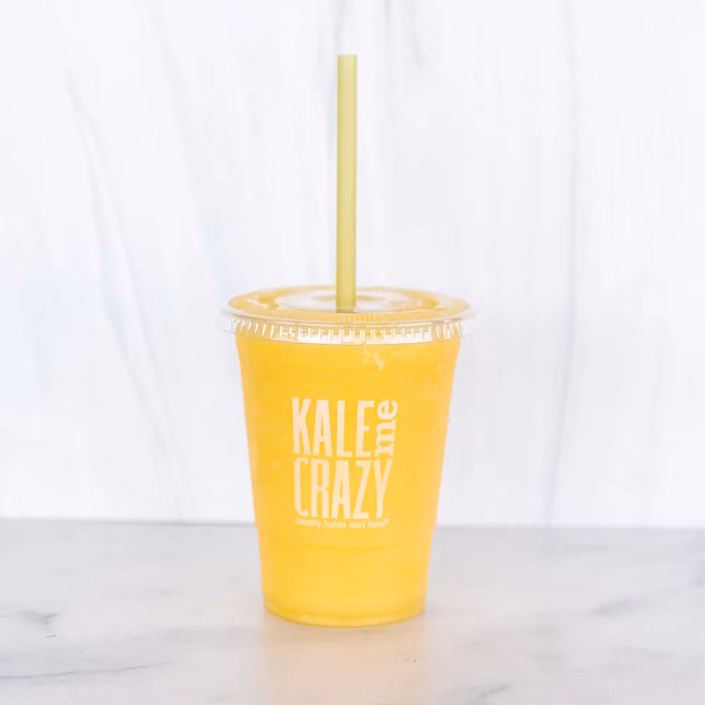 Yellow drink in Kale Me Crazy plastic cup with a straw.