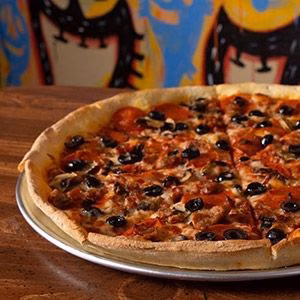 Large pizza with pepperoni, olives, and mushrooms on a metal tray.