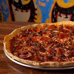 A large pepperoni and meat pizza on a metal tray.