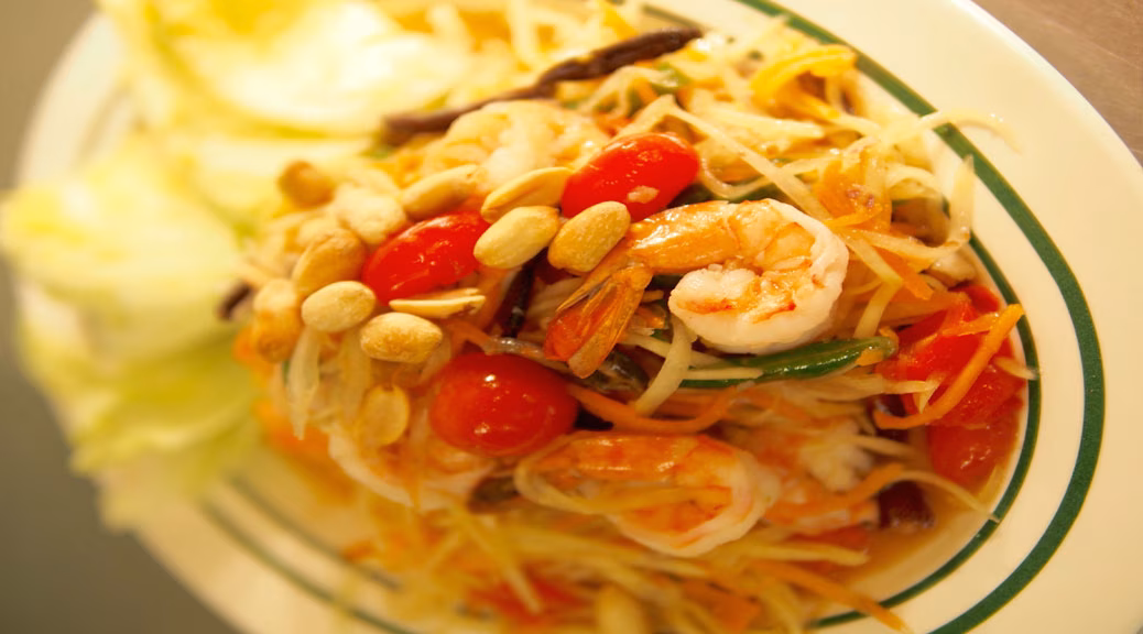 Papaya salad with shrimp, cherry tomatoes, and peanuts.