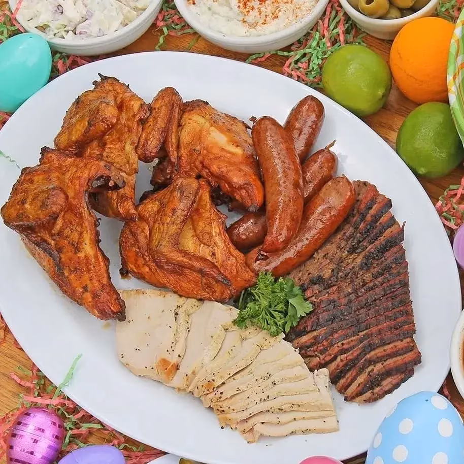 Roasted chicken, sausages, sliced brisket, and turkey on an Easter platter.